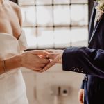 woman putting wedding ring on groom s finger