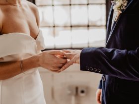 woman putting wedding ring on groom s finger