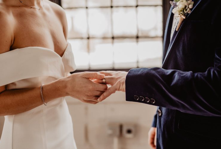 woman putting wedding ring on groom s finger