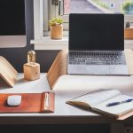 black and silver laptop on brown wooden rack