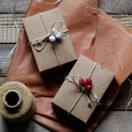 two wrapped presents sitting on top of a wooden table