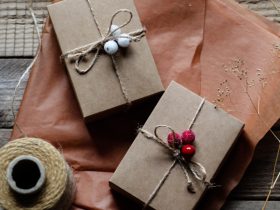 two wrapped presents sitting on top of a wooden table