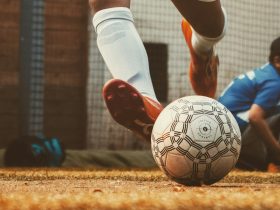 person in white and red soccer jersey kicking soccer ball