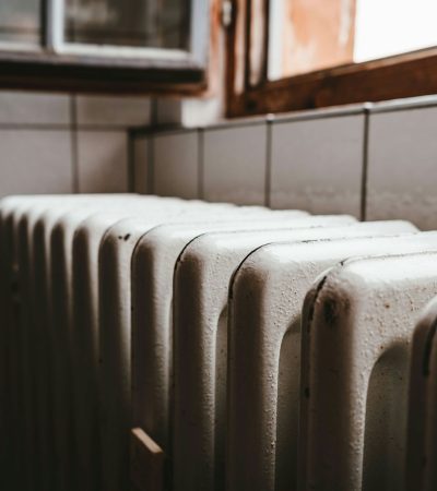 white radiator heater beside brown wooden window