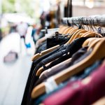 Vrouw die badpakken bekijkt aan een sale-rek in een modezaak
