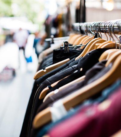Vrouw die badpakken bekijkt aan een sale-rek in een modezaak