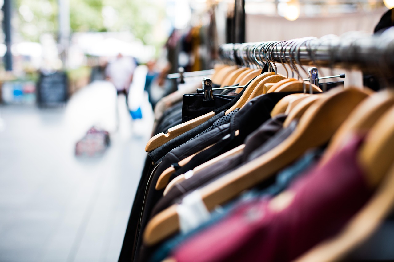 Vrouw die badpakken bekijkt aan een sale-rek in een modezaak