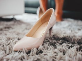 Elegante witte bruidsschoenen met lage hak op een houten ondergrond