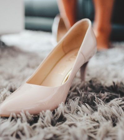 Elegante witte bruidsschoenen met lage hak op een houten ondergrond