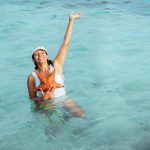 Vrouw die corrigerende zwemkleding past op het strand