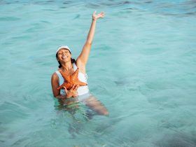 Vrouw die corrigerende zwemkleding past op het strand