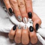 Handen met beschadigde nagels naast potjes met natuurlijke ingrediënten zoals olijfolie en honing voor een DIY nagelbehandeling