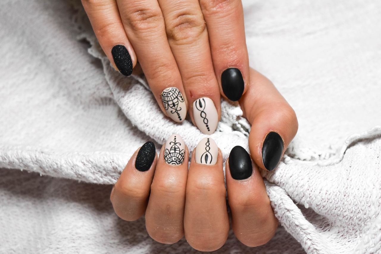 Handen met beschadigde nagels naast potjes met natuurlijke ingrediënten zoals olijfolie en honing voor een DIY nagelbehandeling