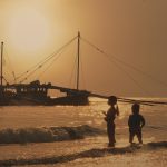 Kinderen in kleurrijke strandoutfits spelen op het strand in de zomer