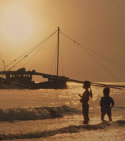 Kinderen in kleurrijke strandoutfits spelen op het strand in de zomer