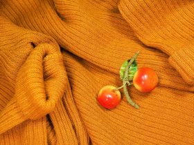 Een vintage emailbroche vastgespeld op een donkere coltrui als winteraccessoire