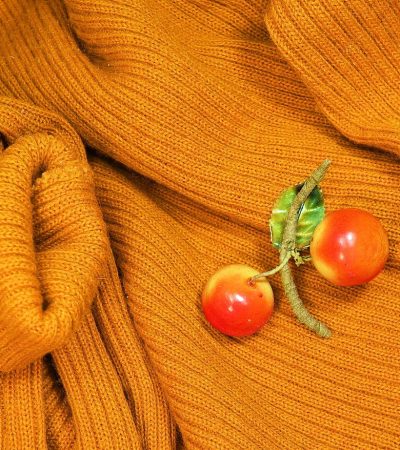 Een vintage emailbroche vastgespeld op een donkere coltrui als winteraccessoire