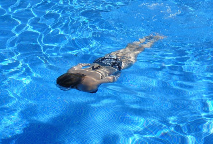 Vrouw die baantjes trekt in een overdekt zwembad met een sportief badpak