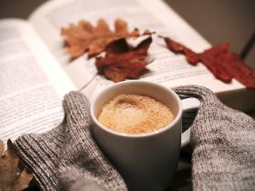 Gelaagde gouden kettingen gedragen over een warme herfsttrui