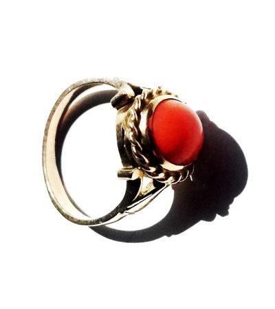 Een goudsmid past een gouden ring aan op een werkbank in een atelier