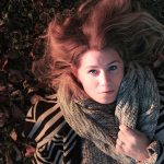 Vrouw met een elegant gedrapeerde sjaal in herfstkleuren