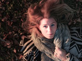 Vrouw met een elegant gedrapeerde sjaal in herfstkleuren