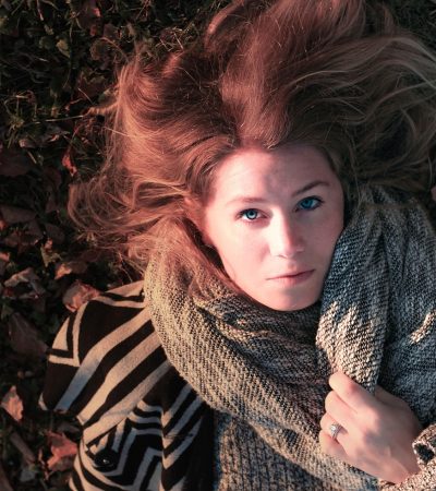 Vrouw met een elegant gedrapeerde sjaal in herfstkleuren
