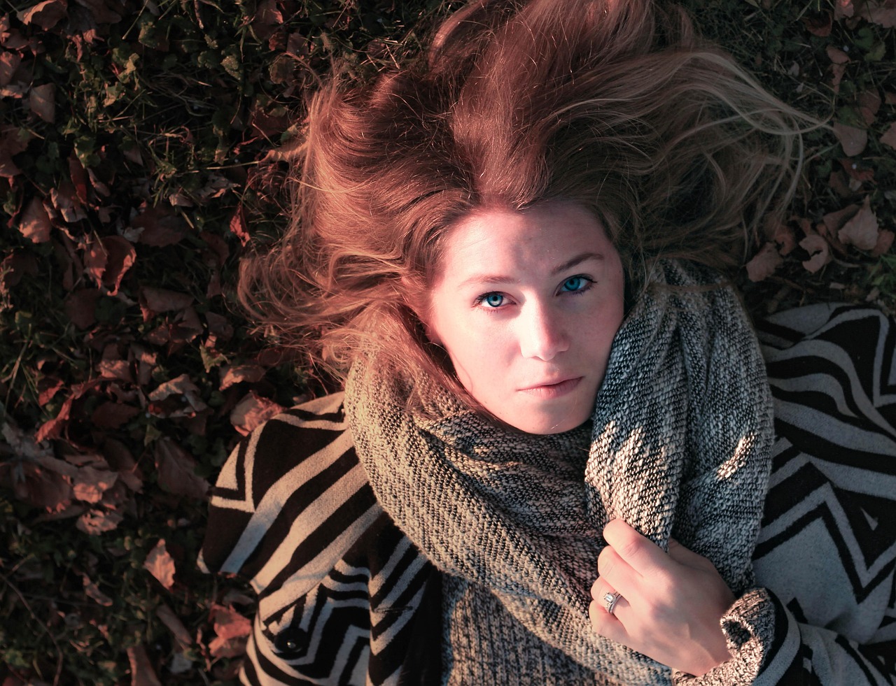 Vrouw met een elegant gedrapeerde sjaal in herfstkleuren