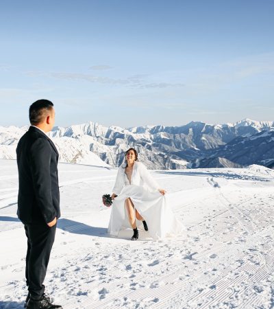 Bruid met een elegante witte cape over haar trouwjurk buiten in de winter