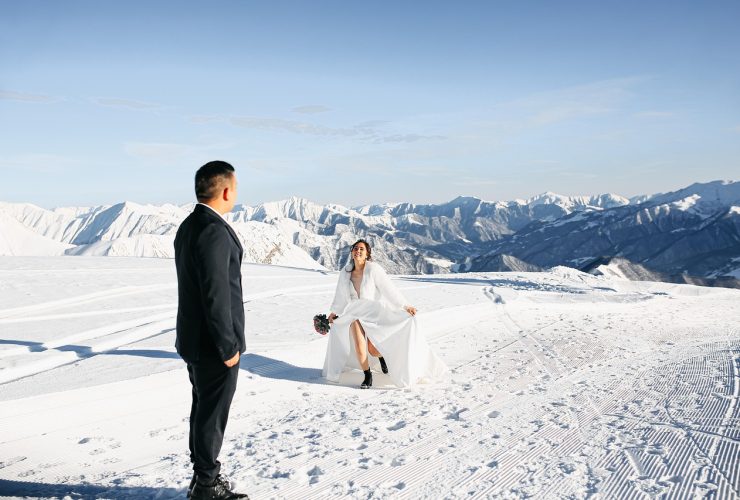 Bruid met een elegante witte cape over haar trouwjurk buiten in de winter