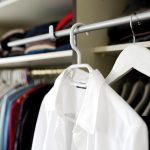 Vrouw die kleding kiest uit een overzichtelijke kledingkast voor een hybride werkdag