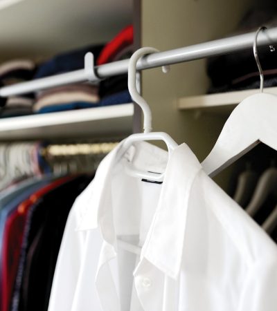 Vrouw die kleding kiest uit een overzichtelijke kledingkast voor een hybride werkdag