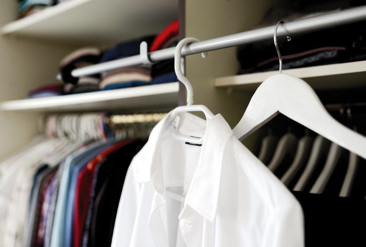 Vrouw die kleding kiest uit een overzichtelijke kledingkast voor een hybride werkdag